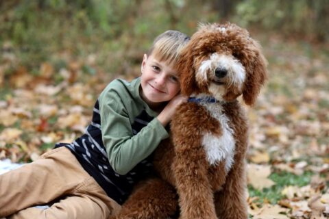 Reggie smiling with Goldendoodle puppy gift